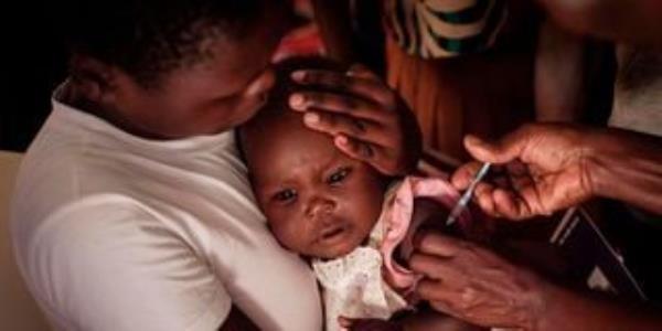 A child receives a shot during the launch of the extension of the world’s first malaria vaccine 